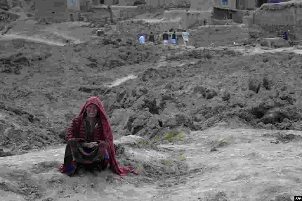 Seorang warga menangis sambil duduk di atas lumpur di distrik Argo, provinsi Badakhshan (3/5), setelah tanah longsor masif menimpa desanya.