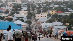 FILE -- People walk along a street in Mogadishu in Sept. 28, 2013. Elections are scheduled for October and November, but officials fear they may be delayed.