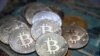 This illustration photograph taken on July 19, 2021 in Istanbul shows a physical banknote and coin imitations of the Bitcoin crypto currency. (Photo by Ozan KOSE / AFP)