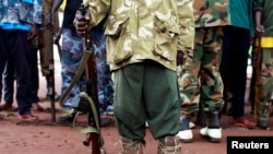 FILE - A former child soldier holds a gun as they participate in a child soldiers' release ceremony, outside Yambio, South Sudan, Aug. 7, 2018. 
