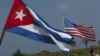La gente de un club náutico local lleva las banderas cubana y estadounidense a la costa para mirar a la nadadora estadounidense Diana Nyad, el 18 de agosto de 2012.