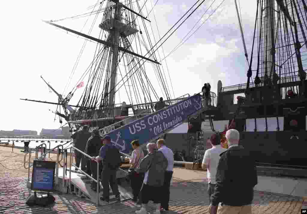 Visitors to the U.S.S. Constitution, the oldest ship in the United States Navy, line up and walk up the gang plank to the top deck for a tour in Boston, Massachusetts, Oct. 17, 2013.