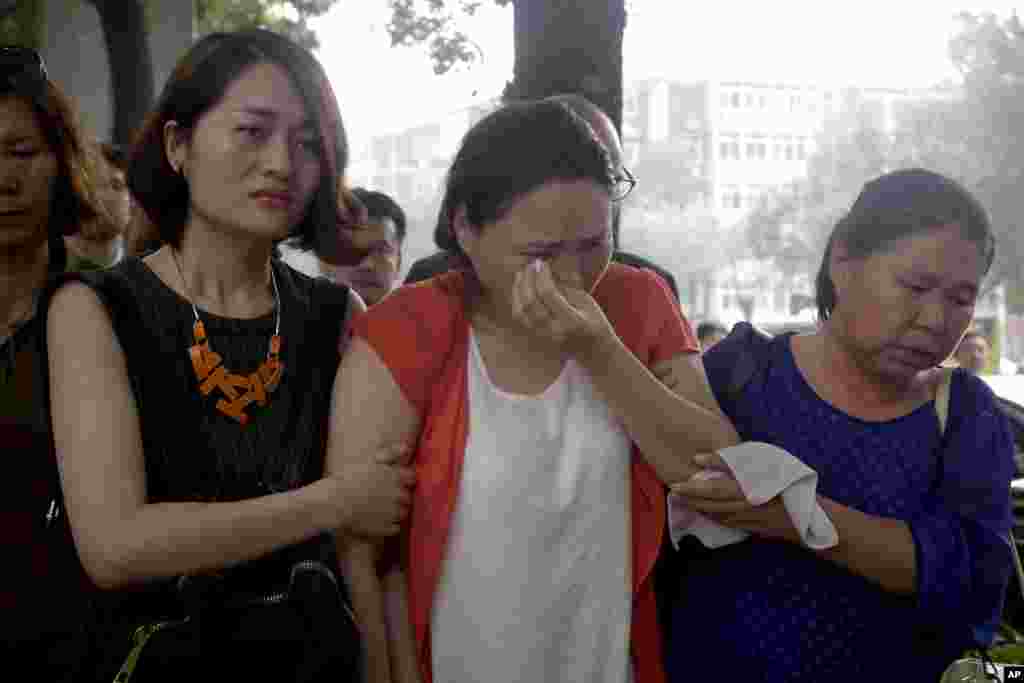 被拘禁人权人士勾洪国(网名戈平)的妻子樊丽丽(中)在被拘押律师王全璋的妻子李文足等人陪伴下 在天津第二中级人民法院门前抗议。