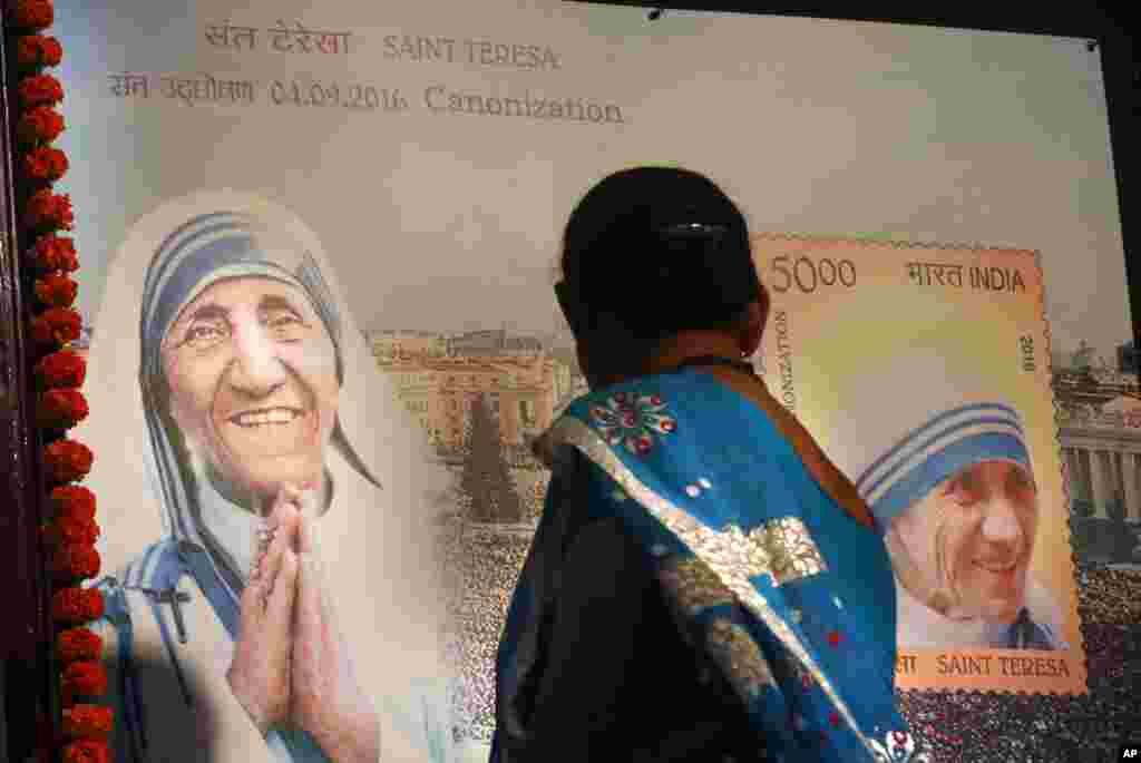 Seorang perempuan Kristen di India melihat perangko Bunda Teresa dalam acara di Mumbai (4/9). (AP/Rafiq Maqbool)