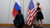 Сотрудник устанавливает российский флаг рядом с флагом США (архивное фото)