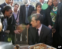 FILE - French President Nicolas Sarkozy, right, listens to representatives of French suburbs after he unveiled the much-awaited, far-reaching plan for reinvigorating suburban housing projects and integrating their young people, Feb. 8, 2008 at the Elysee Palace in Paris.