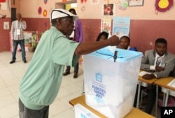 FILE - A voter casts his vote in elections in Luanda, Angola, Aug. 23, 2017.