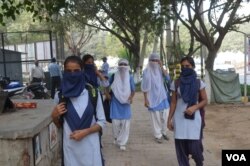 School students try to protect themselves from the dirty air in Delhi, Nov. 8, 2017. (A. Pasricha/VOA)
