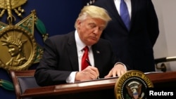 Presidente Donald Trump assinado a ordem de restrição de viagens em Janeiro.