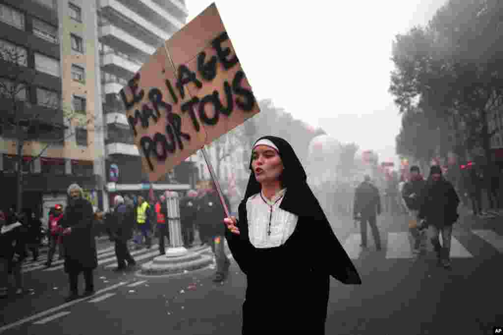 A woman dressed as a nun holds a board reading "marriage for everybody" as part of a demonstration against austerity in Paris, November 14, 2012.