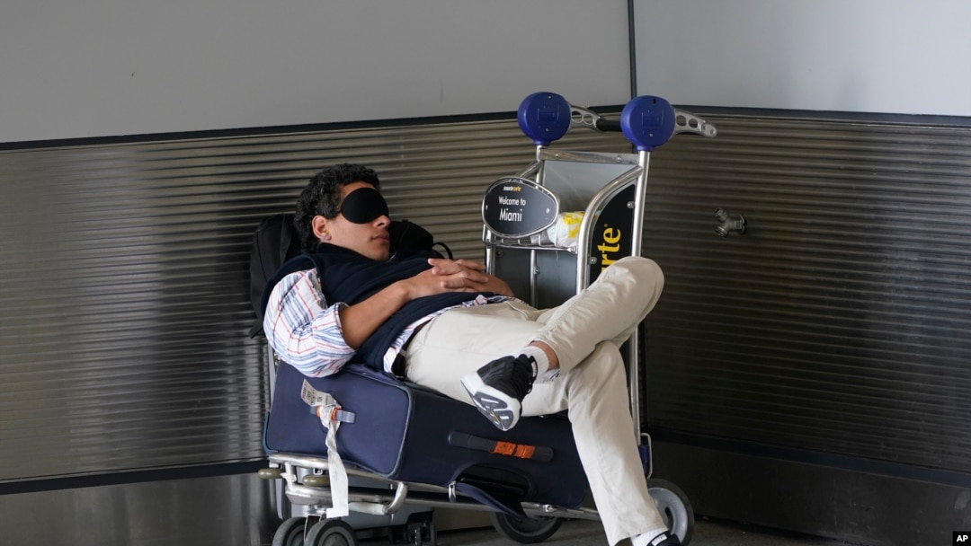 ARHIVA Putnik drema čekajući taksi ispred međunarodnog aerodroma u Majamiju, 1. jula 2022. (Foto: AP/Wilfredo Lee)