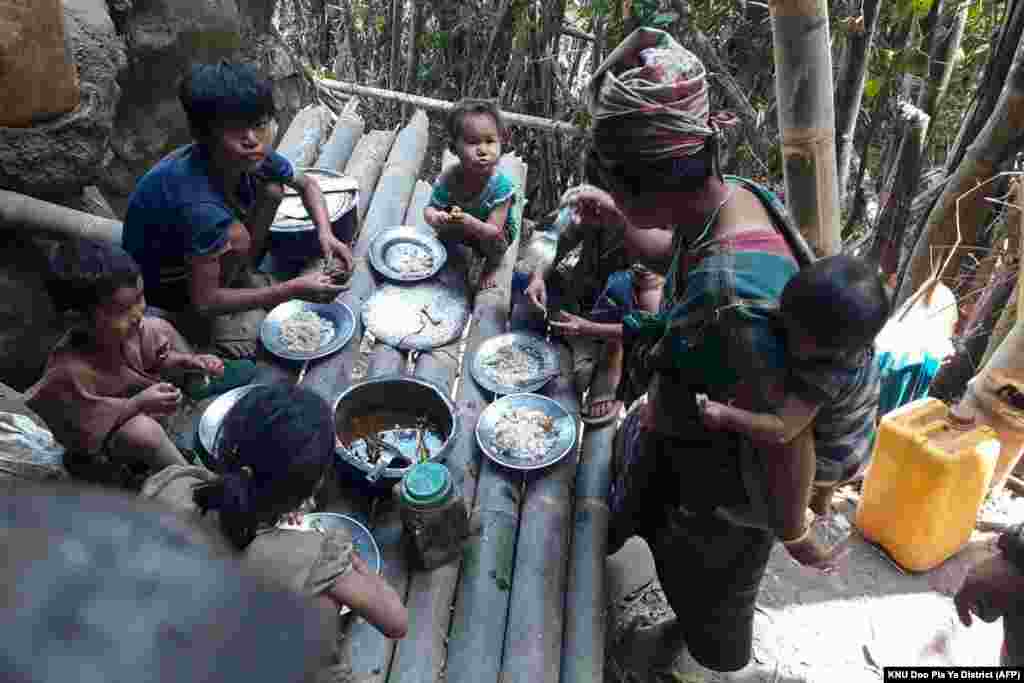 Karen villagers eat in the KNU Brigade 5 region in Myanmar's Karen state, after airstrikes by Myanmar military in the area following the February military coup.