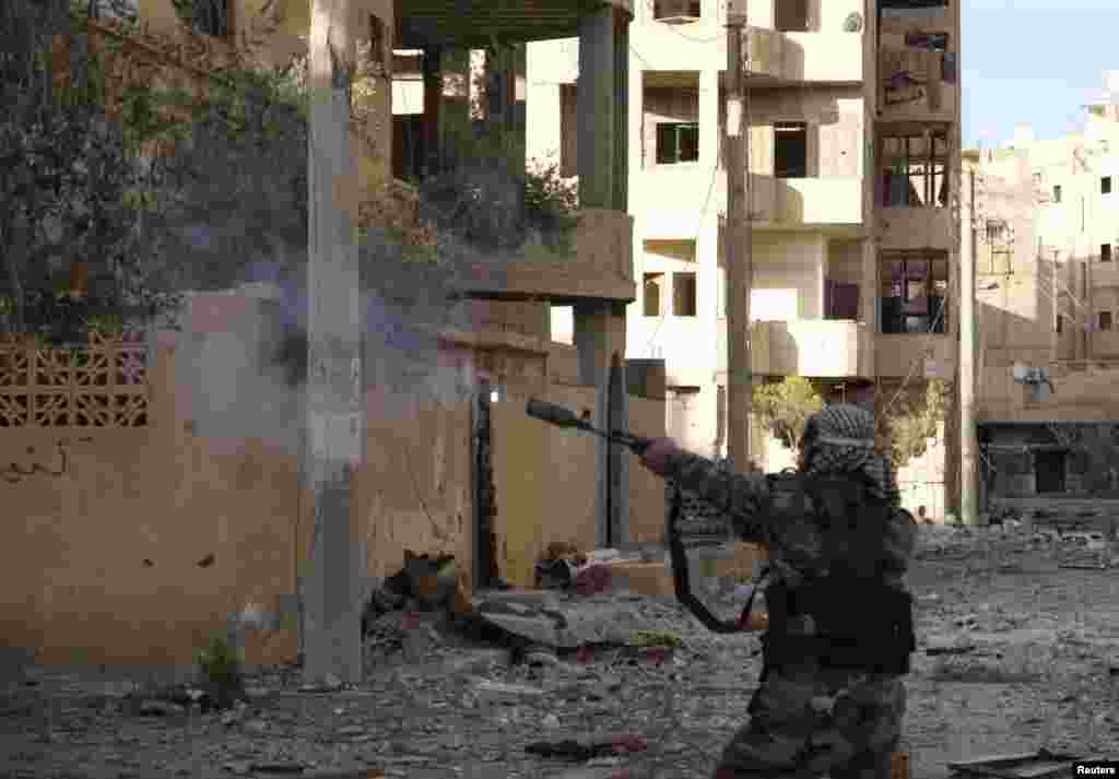 A member of the Free Syrian Army fires his weapon in Deir al-Zor, Syria, March 7, 2013.