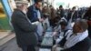 An Afghan money changer, second from right, counts a pile of Pakistani currency banknotes at a money exchange market in Kabul, Dec. 5, 2016.