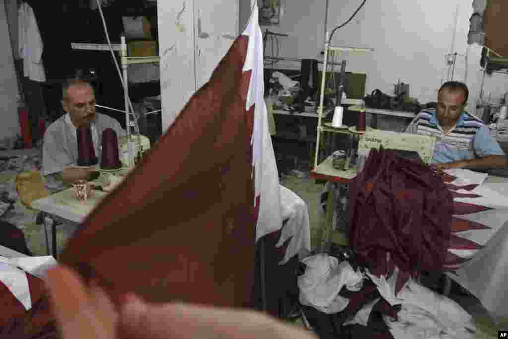 Thợ may người Palestine Eyad Absi (trái) và Salama Ashour may quốc kỳ của Qatar trong cửa hiệu nhân dịp Quốc vương Qatar Hamad bin Khalifa al-Thani chính thức ghé thăm Gaza City ngày 23 tháng 10, 2012.