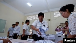 Para anggota Komite Pemilihan Umum menghitung surat suara dalam pemilihan Senat di Phnom Penh, Kamboja, 25 Februari 2018.