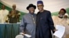 FILE - Nigeria's President Goodluck Jonathan, center-left, and opposition candidate Gen. Muhammadu Buhari, center-right, hug and shake hands after signing a renewal of their pledge to hold peaceful "free, fair, and credible" elections, at a hotel in the capital Abuja, March 26, 2015. 