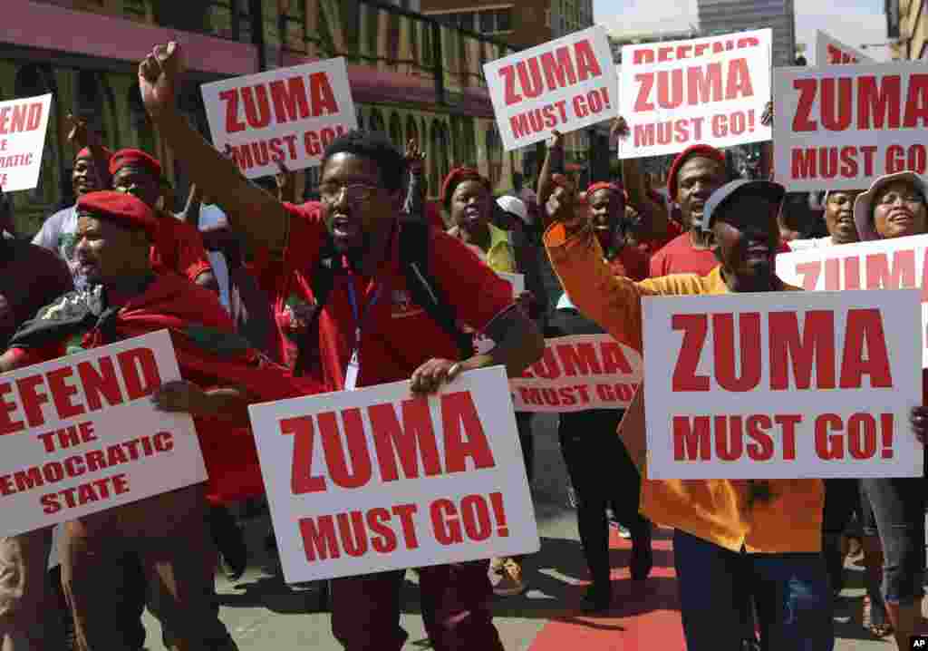 Manifestantes com cartazes exigindo saída de Zuma.