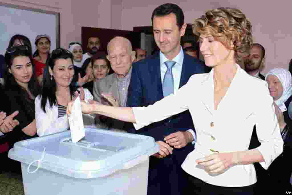 A picture from the official Facebook page of Syria's first lady Asma al-Assad shows Syrian President Bashar al-Assad watching on as Asma casts her vote at a polling station in Maliki, Damascus, May 3, 2014.