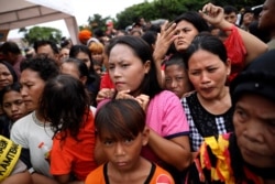 People queue up to receive food at an aid distribution point for those affected by the floods in Jakarta, Indonesia, Jan. 4, 2020.