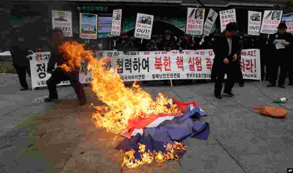 Những người Hàn Quốc biểu tình trong thủ đô Seoul, đốt cờ Bắc Triều Tiên sau khi được tin về vụ thử hạt nhân của Bắc Triều Tiên. 12/2/2013.