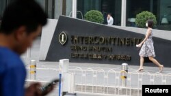 A man uses a phone outside the InterContinental hotel in Beijing district of Sanlitun, China, Aug. 1, 2017. China is filling the holes in it's Great Firewall, and that includes one of the last places to find unfiltered internet content: international hote