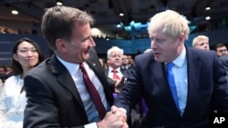 Jeremy Hunt, left, congratulates Boris Johnson after the announcement of the result in the ballot for the new Conservative party leader, in London, Tuesday, July 23, 2019.