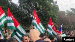 Протестующие митингуют у здания парламента в Сухуми, столице сепаратистского региона Грузии Абхазии, 15 ноября 2024 года.