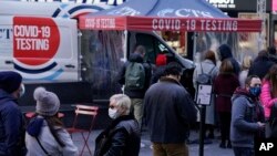 13 Aralık 2021 - New York'un ünlü Times Meydanı'nda Covid-19 testi yaptırmak isteyenler sırada bekliyor. 