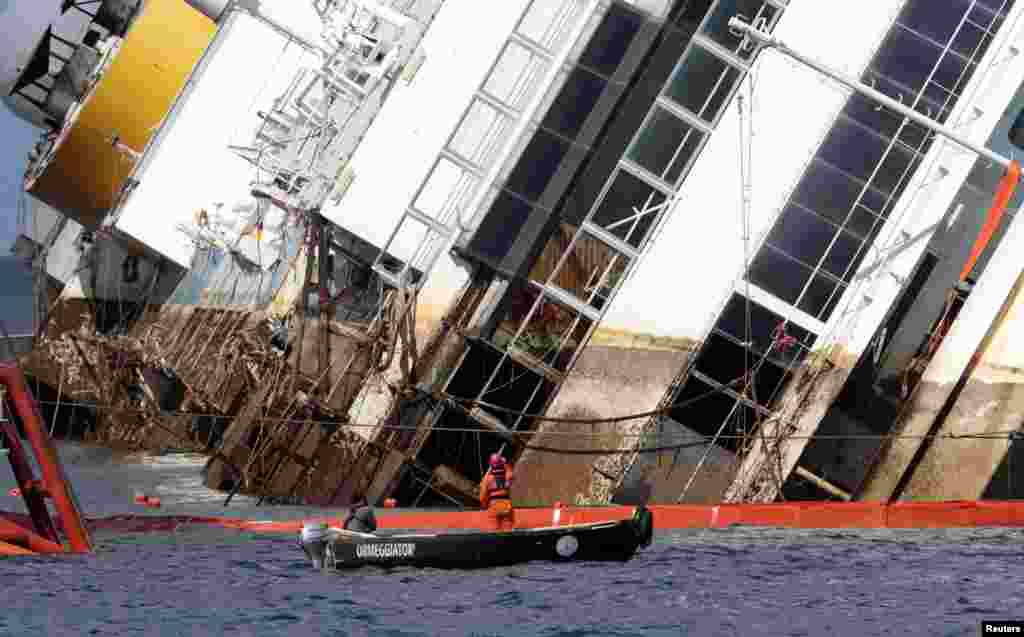 Para pekerja memulai usaha untuk menegakkan kembali kapal pesiar Costa Concordia yang terbalik 20 bulan lalu di dekat pelabuhan Giglio, Italia.