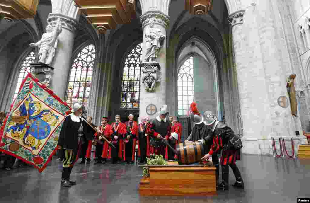 Para anggota "ksatria pembuat bir" membawa sebuah tong bir ke dalam Katedral Sint-Gudule di Brussels, Belgia, dalam perayaan Santo-Arnould, Santo yang dipercaya sebagai pelindung pembuat bir.