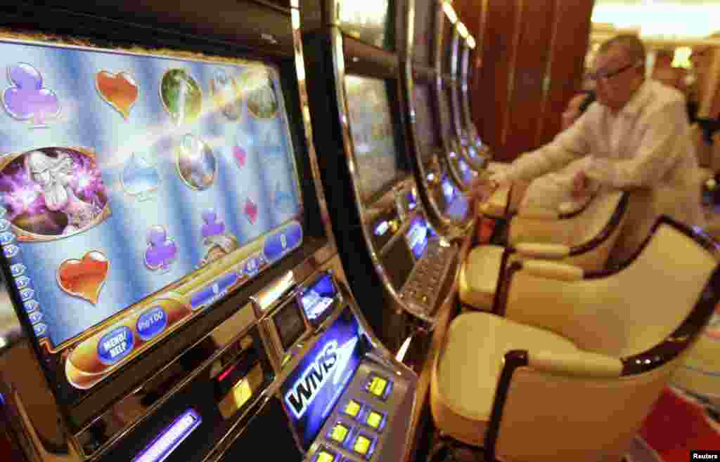 Orang-orang memainkan mesin judi dalam pembukaan Solaire Casino-Resort di Pasay city, Manila, Filipina