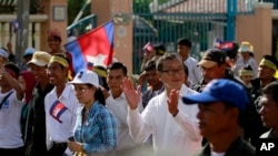 Pemimpin oposisi Kamboja Sam Rainsy (tengah) bertepuk tangan saat memimpin para pendukungnya melakukan aksi unjuk rasa di Phnom Penh, Kamboja (15/9).