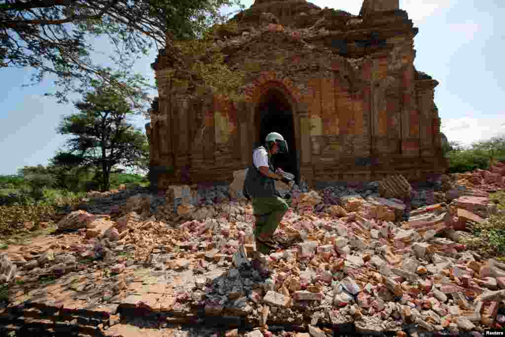 A photographer walks outside a collapsed pagoda after an earthquake in Bagan, Myanmar.
