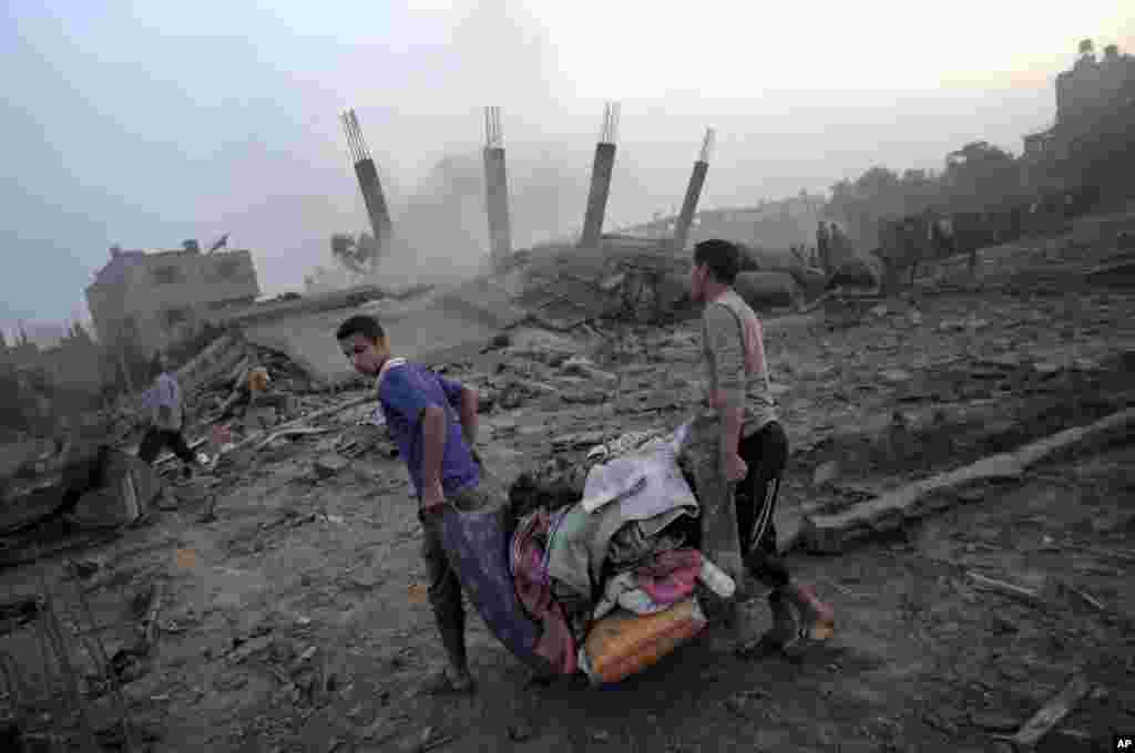 Warga Palestina mencoba menyelamatkan apa yang tersisa dari puing-puing rumah yang dihancurkan oleh serangan udara Israel di kota Gaza (8/7). (AP/Khalil Hamra)