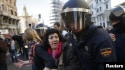 Protesters are pushed away by Spanish police officers during a 24-hour nationwide general strike in central Madrid November 14, 2012.