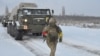 A service member of the Ukrainian Armed Forces runs near self-propelled multiple rocket launcher systems during drills in the Kherson region, Ukraine, in this handout picture released Feb. 1, 2022. 
