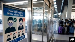 Sebuah poster pengumuman yang memberi informasi tentang penggunaan masker terpasang di Bandara Internasional O'Hare di Chicago, pada 2 Juli 2021. (Foto: AP/Nam Y.Hhuh)