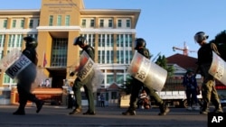 Polisi anti huru-hara Kamboja berbaris di depan Pengadilan Kota Phnom Penh di Phnom Penh, Kamboja untuk bersiap memberikan pengamanan dalam sidang pekerja pabrik dan hak-hak buruh, 30 Mei 2014.
