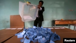 An Afghan election official empties a ballot box for counting at the end of polling in Herat Province, Apr. 5, 2014. 
