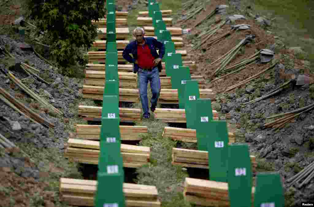 Seorang pria Muslim Bosnia mencari peti jenazah saudaranya yang tewas dalam pembantaian Srebrenica tahun 1995.