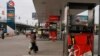FILE PHOTO - A woman walks through a closed Caltex gas station during a strike Monday, May 12, 2014, in Phnom Penh, Cambodia.