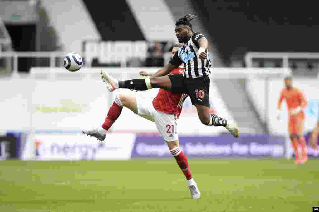 Newcastle's Allan Saint-Maximin, 10, competes for the ball with Arsenal's Calum Chambers during the English Premier League soccer match between Newcastle United and Arsenal at St James' Park stadium, in Newcastle, England.