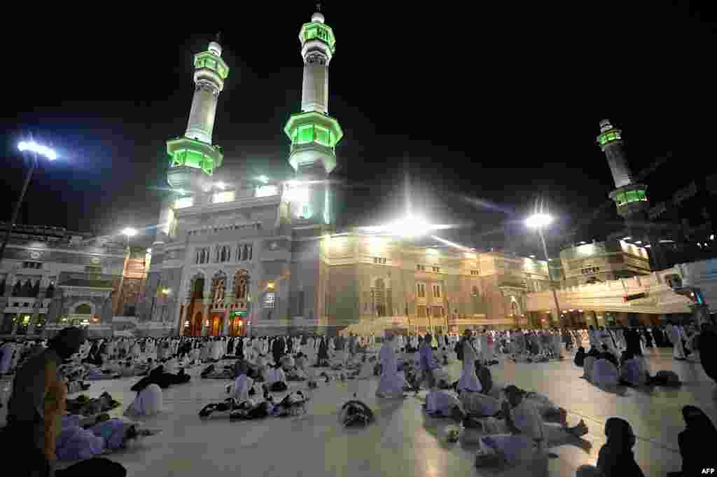 Para jamaah Haji menunggu untuk melakukan shalat subuh di luar pintu masuk Masjidil Haram di Makkah.