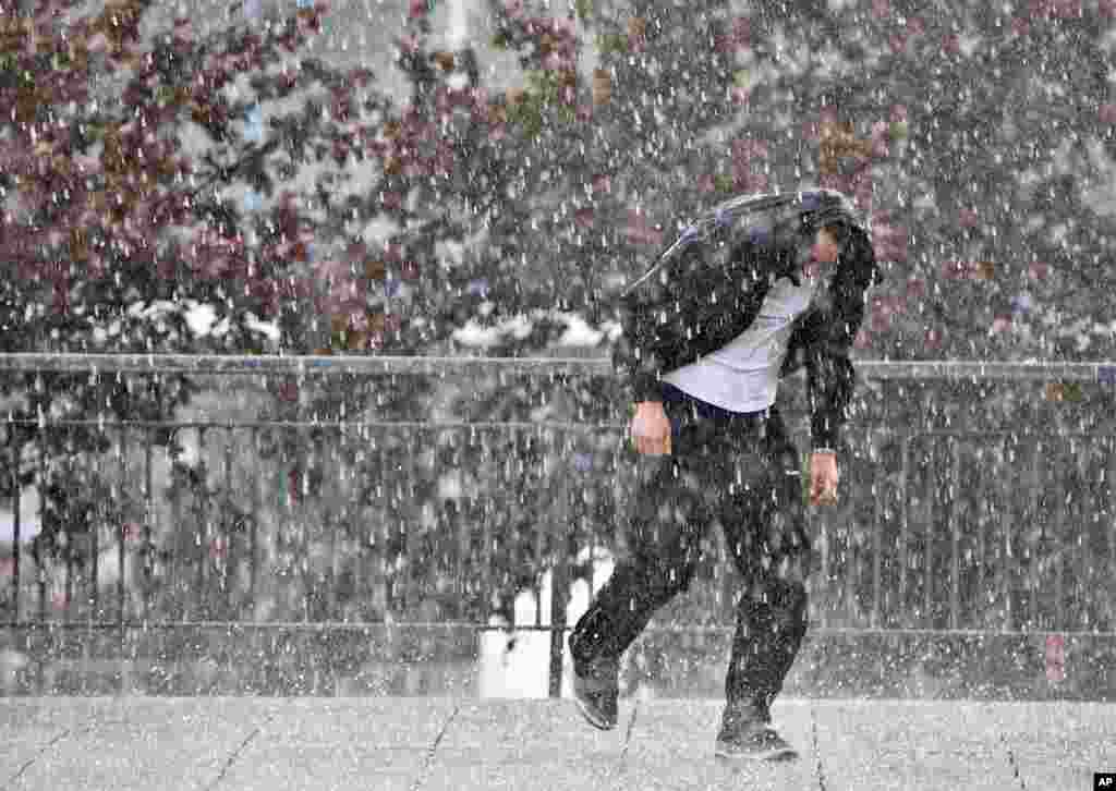 A man runs during heavy rain with hail in Plauen, south eastern Germany.