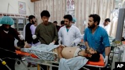 Afghan doctors and medics treat a wounded man at a hospital after a roadside bomb explosion in Kandahar, south of Kabul, April 7, 2014. 