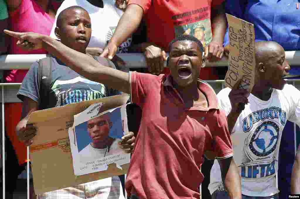 Beberapa orang berduka cita pada upacara pemakaman sopir taksi berusia 27 tahun, Mido Macia di Daveyton, sebelah timur Johannesburg, Afrika Selatan. Sopir taksi Mozambik itu tewas dalam penjara Afrika Selatan setelah sebelumnya diseret di belakang sebuah kendaraan polisi.