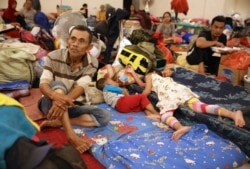 People rest at a temporary shelter in Jakarta, Indonesia, Jan. 3, 2020. Severe flooding in the capital as residents celebrated the new year has killed dozens of people and displaced hundreds of thousands more.