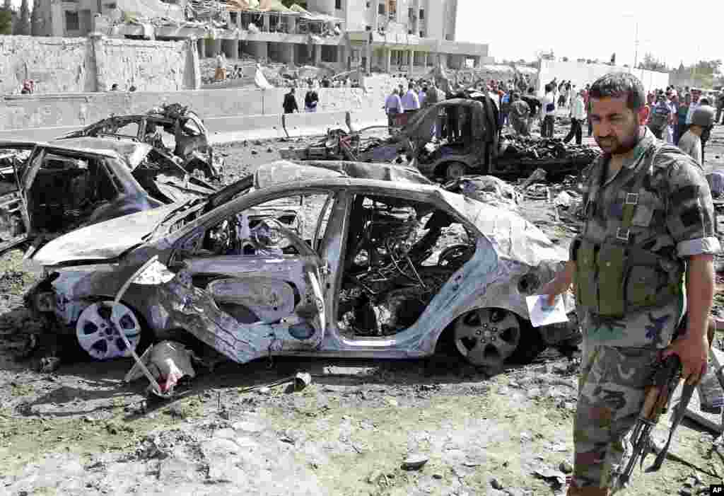 Residents and security personnel gather at the site of an explosion in Damascus.