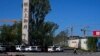 FILE - A woman walks by an Evergrande new housing development in Beijing, China, Sept. 22, 2021. 